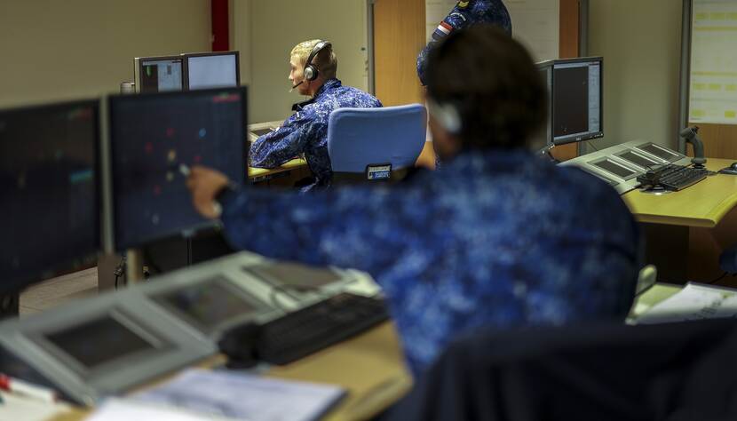 Twee militairen in opleiding zitten achter een aantal beeldschermen.