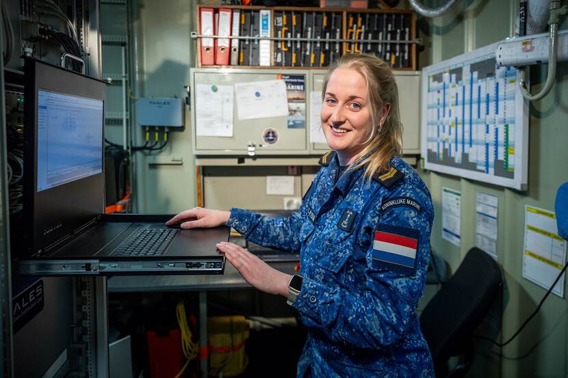 Nynke staat achter een laptop op Zr.Ms. Tromp waar zij werkt.