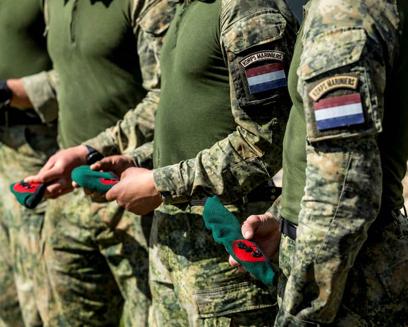 Mariniers op een rij met de groene baret in de hand.