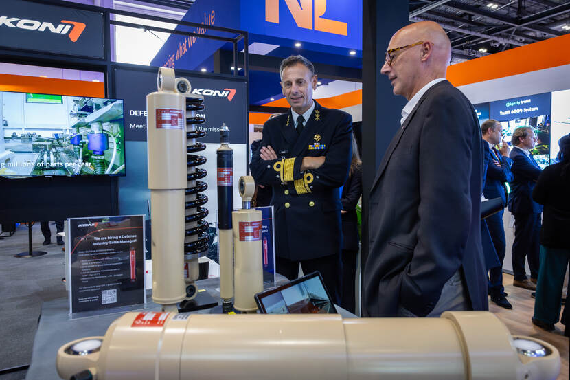 Links staat vice-admiraal Jan Willem Hartman. Hij is in gesprek met een vertegenwoordiger van een van de Nederlandse stands.