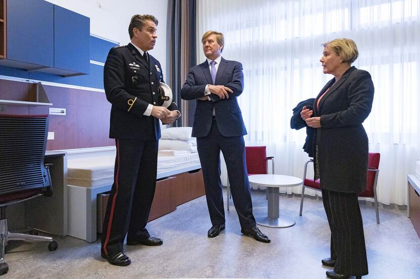 Koning Willem-Alexander en 2 anderen staan te praten op een legeringskamer.