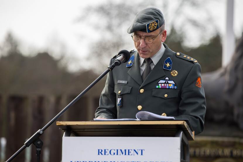 Kolonel Van Loon die vanachter een katheder zijn gehoor toespreekt.