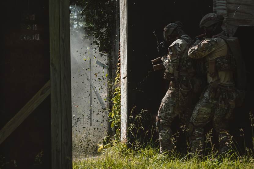 militairen stappen opzij want er wordt een deur opgeblazen