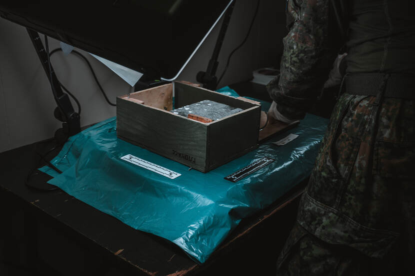 Een kist op een groen zijl in een tijdelijk ingericht lab.