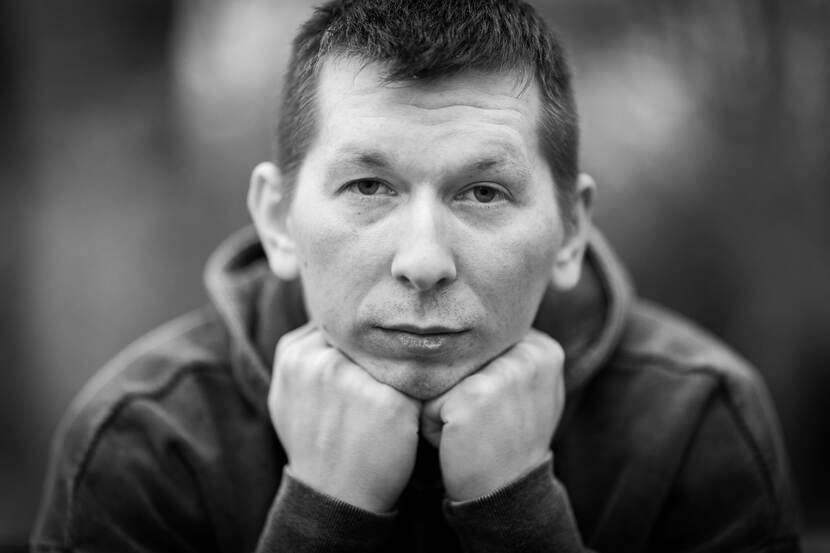 Portretfoto van Illia waarop hij zijn hoofd op zijn knuisten laat rusten.