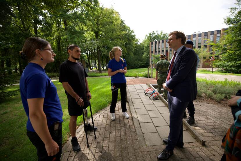 Een militair die een been mist in gesprek met minister Brekelmans.