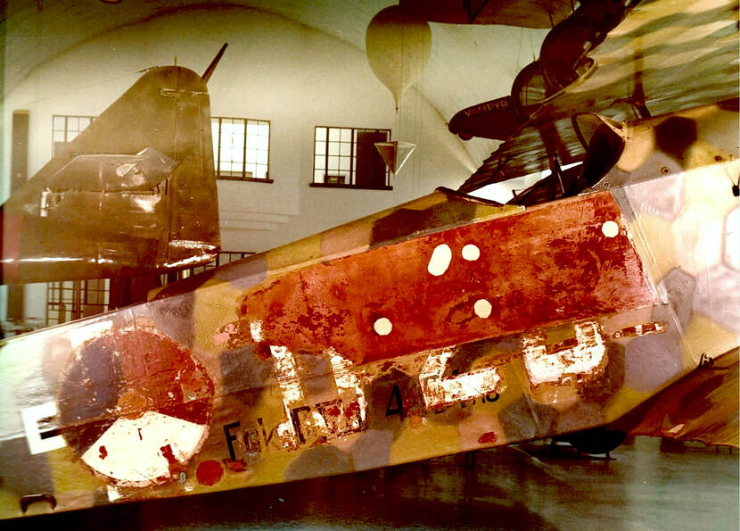Een deel van een verweerde Fokker D.VII met daarop een eveneens verweerd Nederlands roundel.
