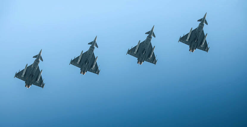 Een strakke formatie van vier Eurofighters van onderaf gezien.