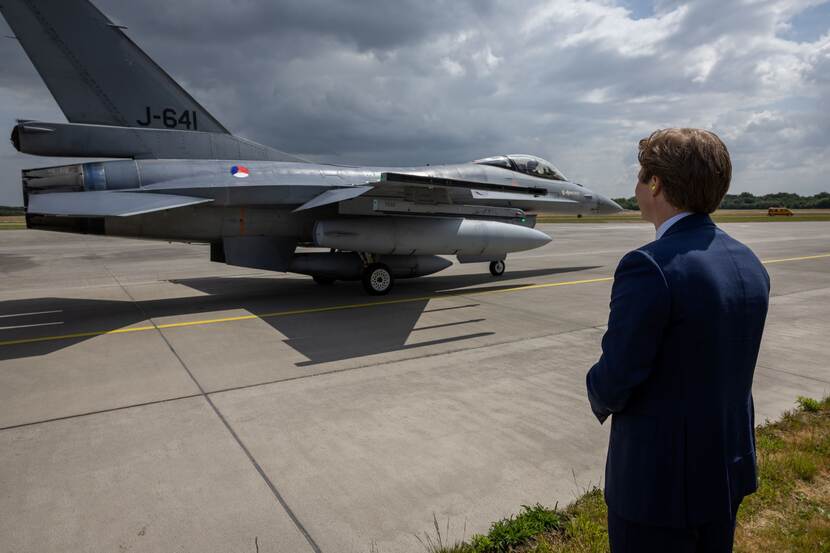 Defensieminster Brekelmans kijkt naar een vertrekkende F-16.