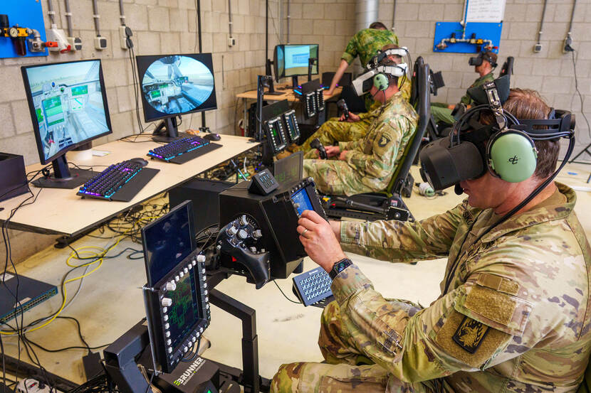 Een aantal militairen met VR-bril naast elkaar in een gebouw met ieder voor zich de cockpitinstrumenten van een Apache.