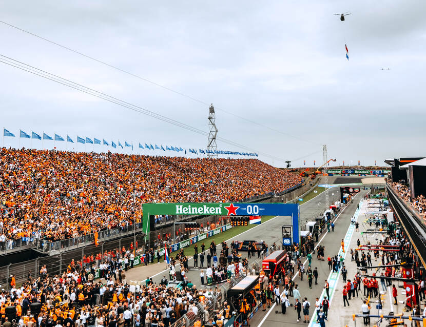 Chinook met daaronder een Nederlandse vlag vliegt boven het Circuit van Zandvoort.