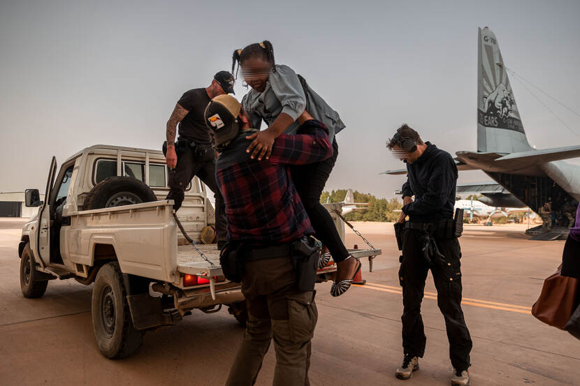 Een voertuig met een BSB-er die een kind uit de wagen tilt.