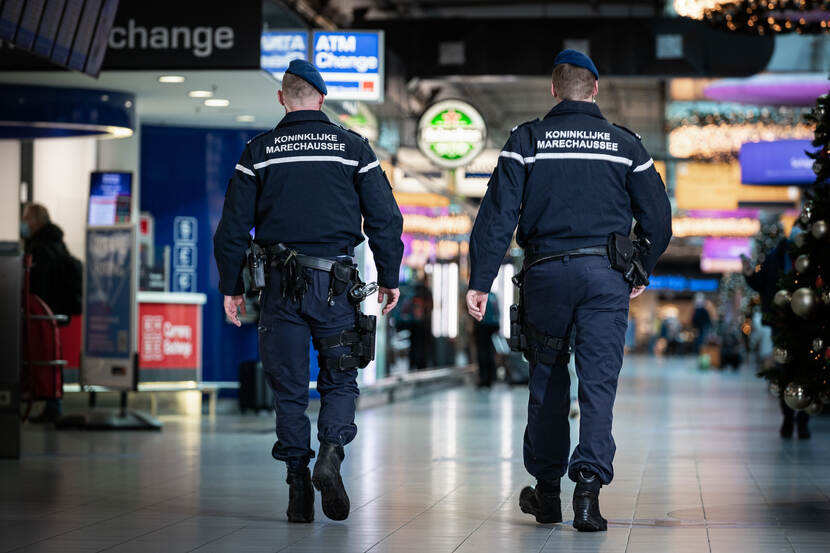 2 marechaussees surveilleren op Schiphol.
