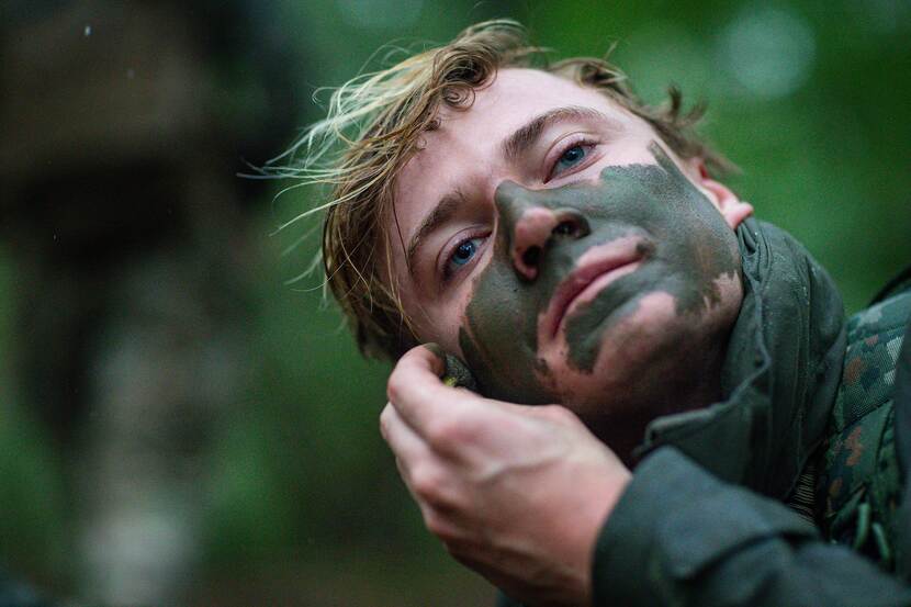 Daniël smeert camouflage op zijn gezicht.