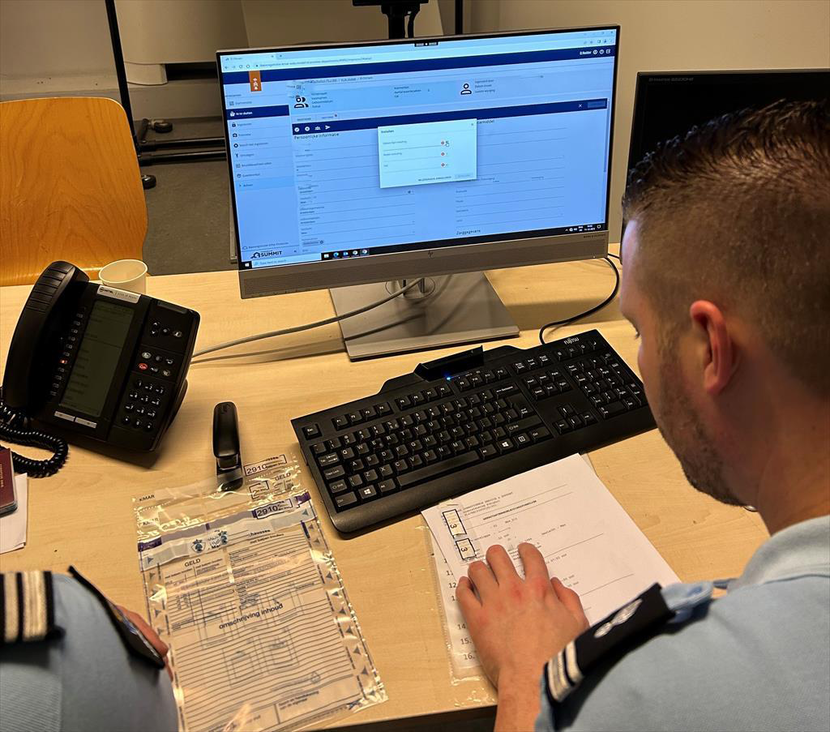 Een collega achter het bureau werkt met SUMMIT.