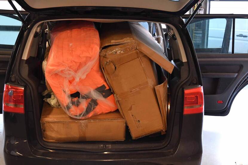 Een achterbak van een voertuig met daarin spullen die gebruikt kunnen worden voor de oversteek van het kanaal.