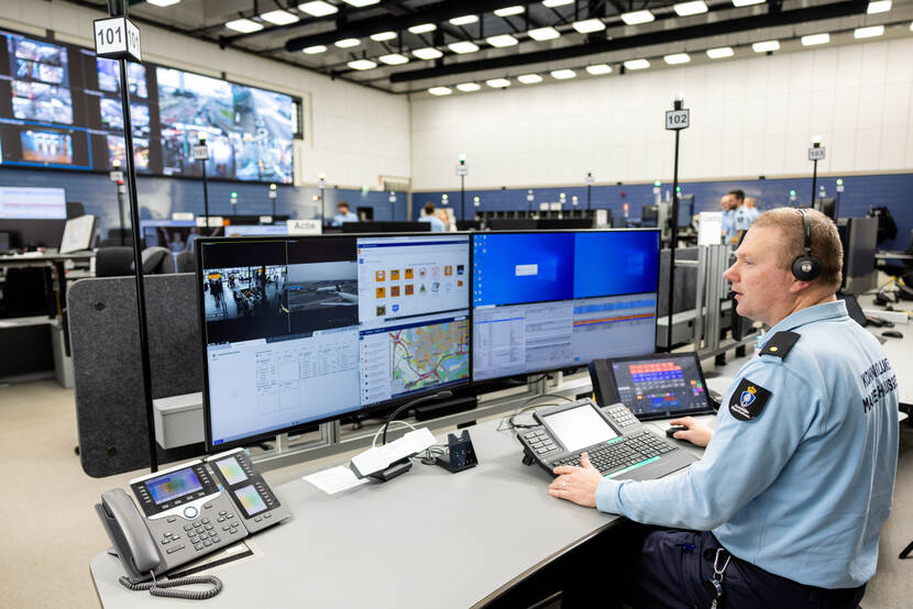 Een centralist zit in de meldkamer.