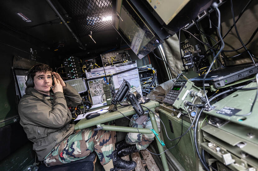 Korporaal van de Mariniers achter de radio's van een BV-206MLU.
