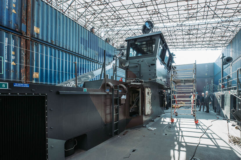 De LCU omringd door een constructie van containers.