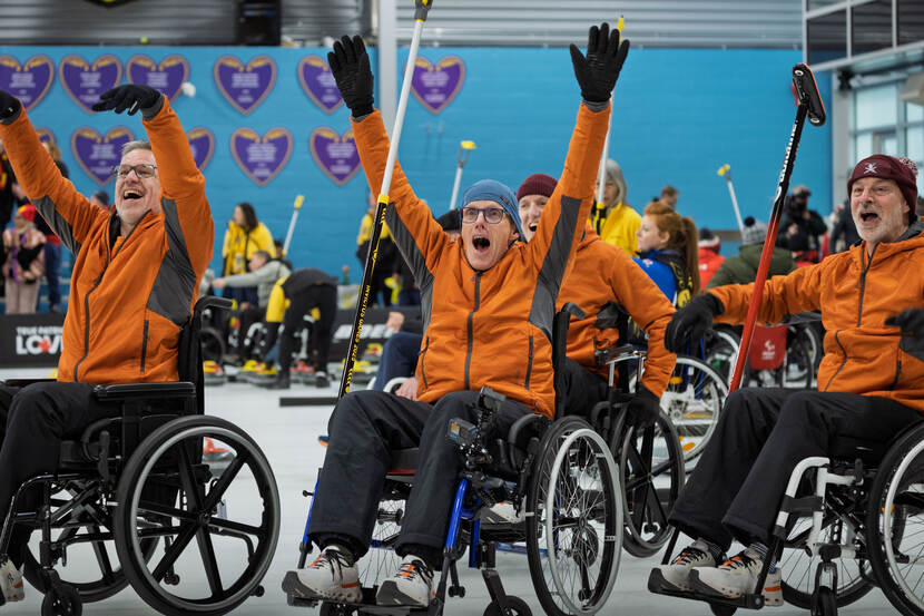 Het Nederlandse rolstoelcurlingteam juicht na een overwinning.