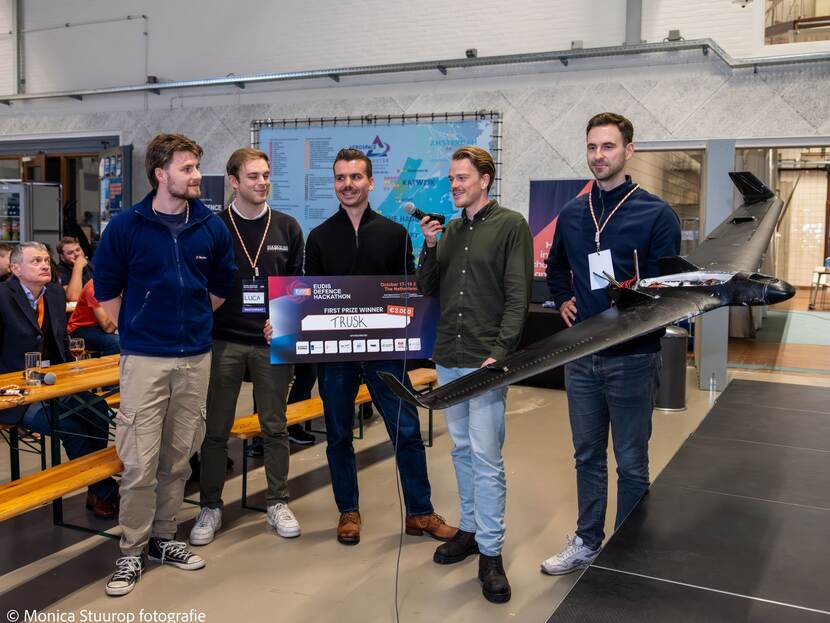 de winnaars van de challenge poseren met een bord van 3000 euro en hun prototype van een interceptordrone.