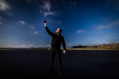 Documentairemaker Bram Roza voor een groot bioscoopscherm waar zijn documentaire wordt afgespeeld.