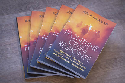 Een stapeltje boeken van Jori Kalkman met op de cover een illustratie van militairen die door oranje/rood vuur naar voren komen.