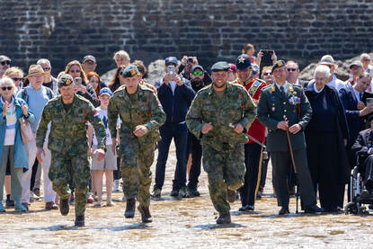 Drie fuseliers rennen richting de zee