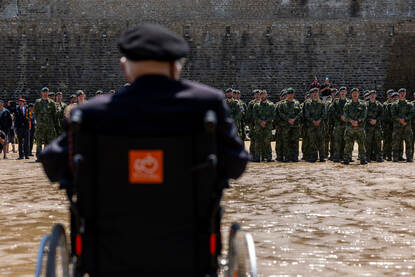 Fuseliers staan opgesteld met hun gezicht richting de zee, terwijl Wolff toekijkt.