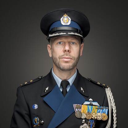 Portret van Wouters met DT aan en pet op.