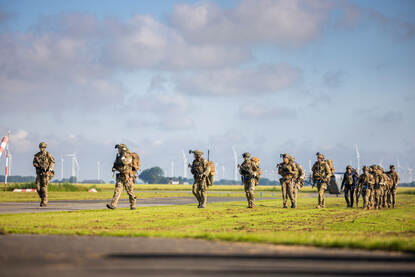 Een peloton militairen van de luchtmobiele brigade is net aangekomen en loopt naar het verzamelpunt.