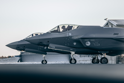Twee geparkeerde F-35-jachtvliegtuigen voor een hangar in Estland.