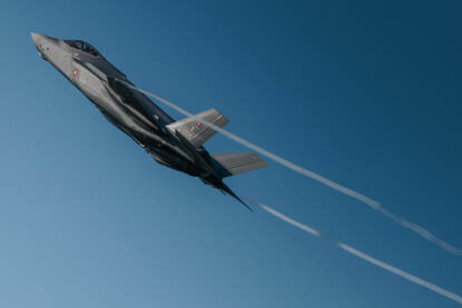 Een Deense F-35A tegen een blauwe lucht.