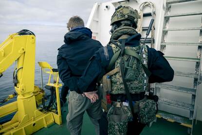 Een militairen houdt iemand aan.