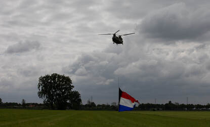 Twee foto’s van een helikopter met daaronder de Nederlandse vlag