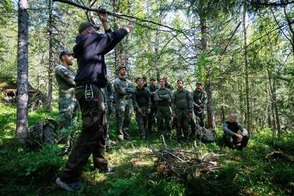 Een groep militairen luistert naar een instructeur. Ze leren onder meer hoe ze vallen kunnen zetten.