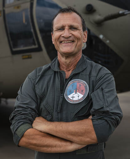 Portret van Lokker in vliegeroverall. Op zijn borst een speciale badge die verwijst naar de tienduizend vlieguren.