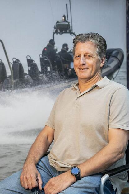 Ed Smit, zittend, in lichtbeige shirt.