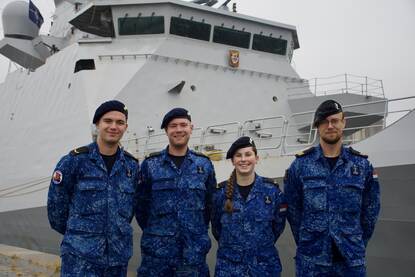 De leerlingen en hun docent staan voor Zr.Ms. De Ruyter.