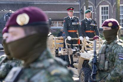 Twee generaals staan in een militair voertuig en kijken naar voren.