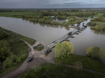 Voertuigen rijden over de brug die de genisten over de IJssel gemaakt hebben.