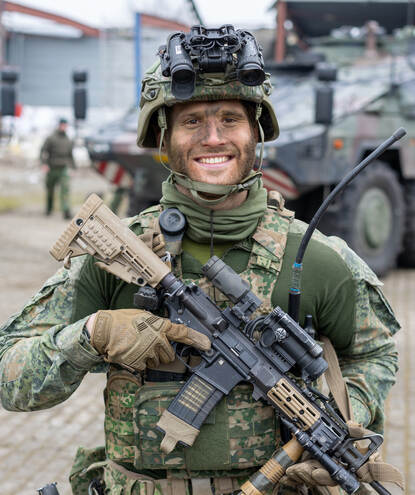 Portretfoto van Sverre in vol ornaat, met wapen en camouflageverf op zin gezicht.