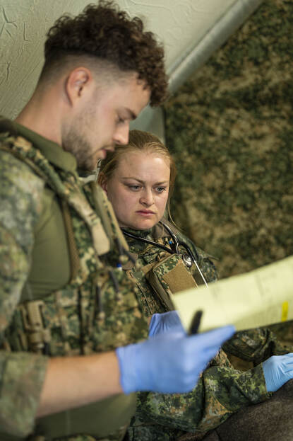 Twee militairen overleggen met elkaar.