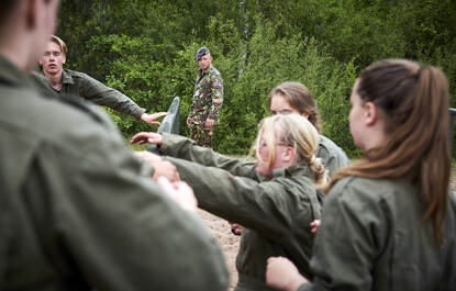 Links: close-up van benen en schoenen van militairen in gevechtstenue op zand. Rechts: jongeren in een groene overal op een hindernisbaan.
