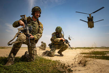Een doorgunner met op de achtergrond een Chinook-transporthelikopter.
