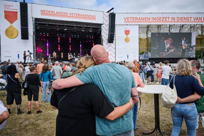 Mensen kijken naar een podium waar muziek wordt gemaakt