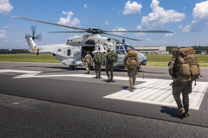 Mariniers lopen naar een NH90 toe