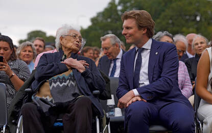 Brekelmans in gesprek met een Nederlands-Indische dame in het publiek.