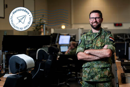 Kapitein Erik Boel poseert in de operatieruimte van de luchtgevechtsleiding tussen de werkstations.