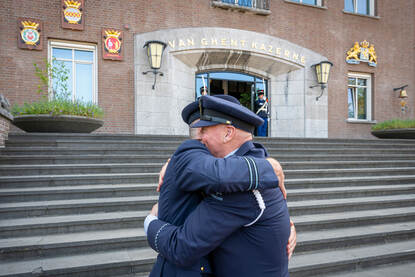 Twee luchtmachtmilitairen die elkaar een stevige omhelzing geven.